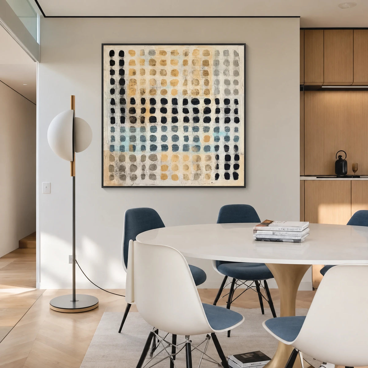 Pebble Grid artwork displayed beside a round dining table with white and blue chairs.