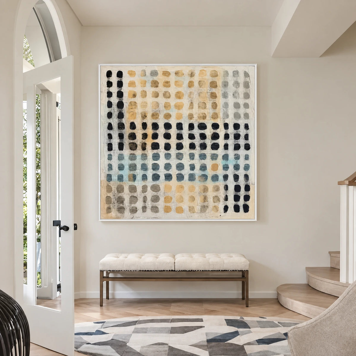 Pebble Grid artwork displayed above a cushioned bench beside an arched doorway and stairs.
