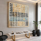 Pebble Grid artwork displayed above a low stone-topped bench in a softly lit interior.