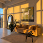 Spotted Grace artwork displayed above a yellow sofa in warm evening light.