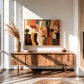 Earthtone Ensemble artwork displayed above a wooden sideboard in sunlight.