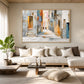 Sunlit Passage artwork displayed above a pale sofa beside tall curtains.