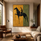Ochre Rider artwork displayed above a low wooden coffee table beside a sunlit sofa.