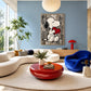 Heartfelt Companion artwork displayed above a pale sofa and red coffee table.