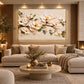 Ivory Branch artwork displayed above a sofa beneath warm ceiling lights.