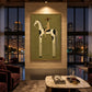 Dappled Rider artwork displayed above red seating beside evening city windows.