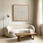 Ivory Rings artwork displayed above a rounded cream sofa.