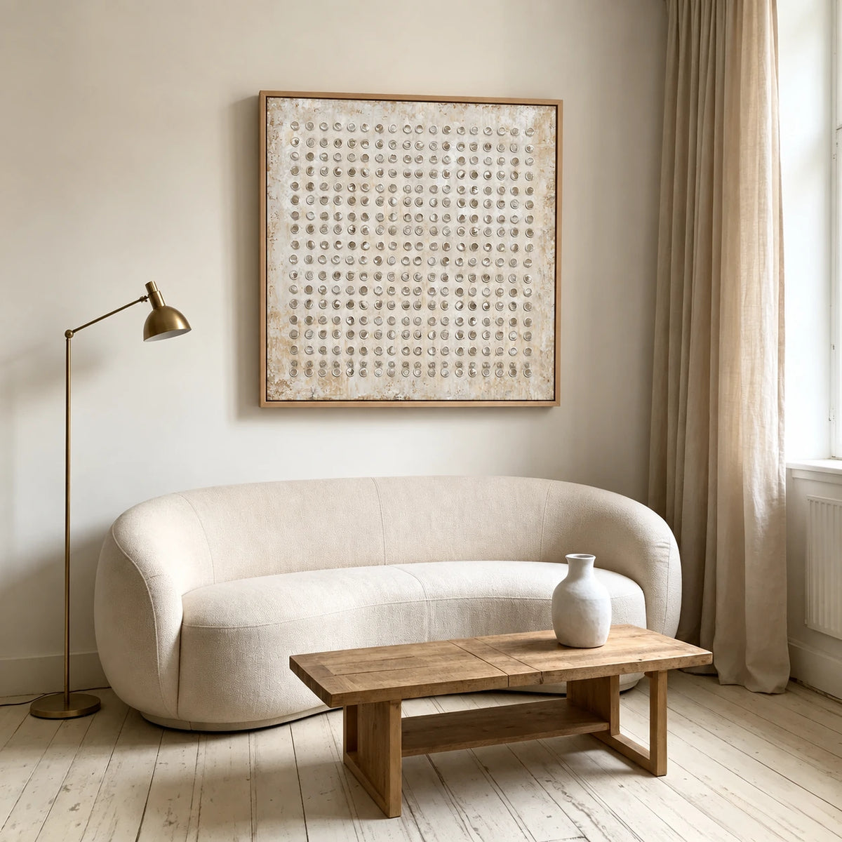 Ivory Rings artwork displayed above a rounded cream sofa.