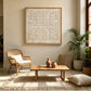 Ivory Rings artwork displayed above a wooden table beside a woven chair.