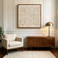 Ivory Rings artwork displayed above a wooden cabinet beside a brass lamp.