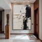 Ivory Divide artwork displayed in a bright entryway beside a wooden pedestal.
