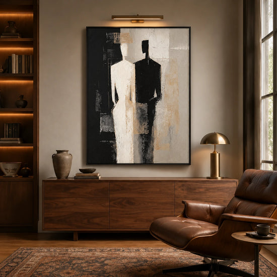 Divided Silhouette artwork displayed above a wooden sideboard beside a leather chair.