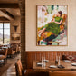 Olive Recline artwork displayed above a dining booth with leather seating.