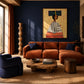 Ochre Poise artwork displayed above an orange sofa against a navy wall.