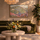 Pastel Highlands artwork displayed above a dark green sofa behind a floral arrangement.