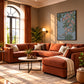 Trailing Orchids artwork displayed above an orange sectional beside arched windows.