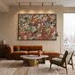 Earthen Mosaic artwork displayed above a brown sofa beside a city-view window.