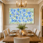 Periwinkle Garden artwork displayed above a dining table beneath a chandelier.