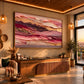 Rose Strata artwork displayed above a wooden console in warm evening light.
