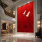 Crimson Flight Wall Art in a slim gold frame displayed in a grand double-height lobby with a curved balcony.
