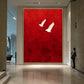 Crimson Flight Wall Art in a slim gold frame on a tall gallery wall, with a visitor nearby for scale.