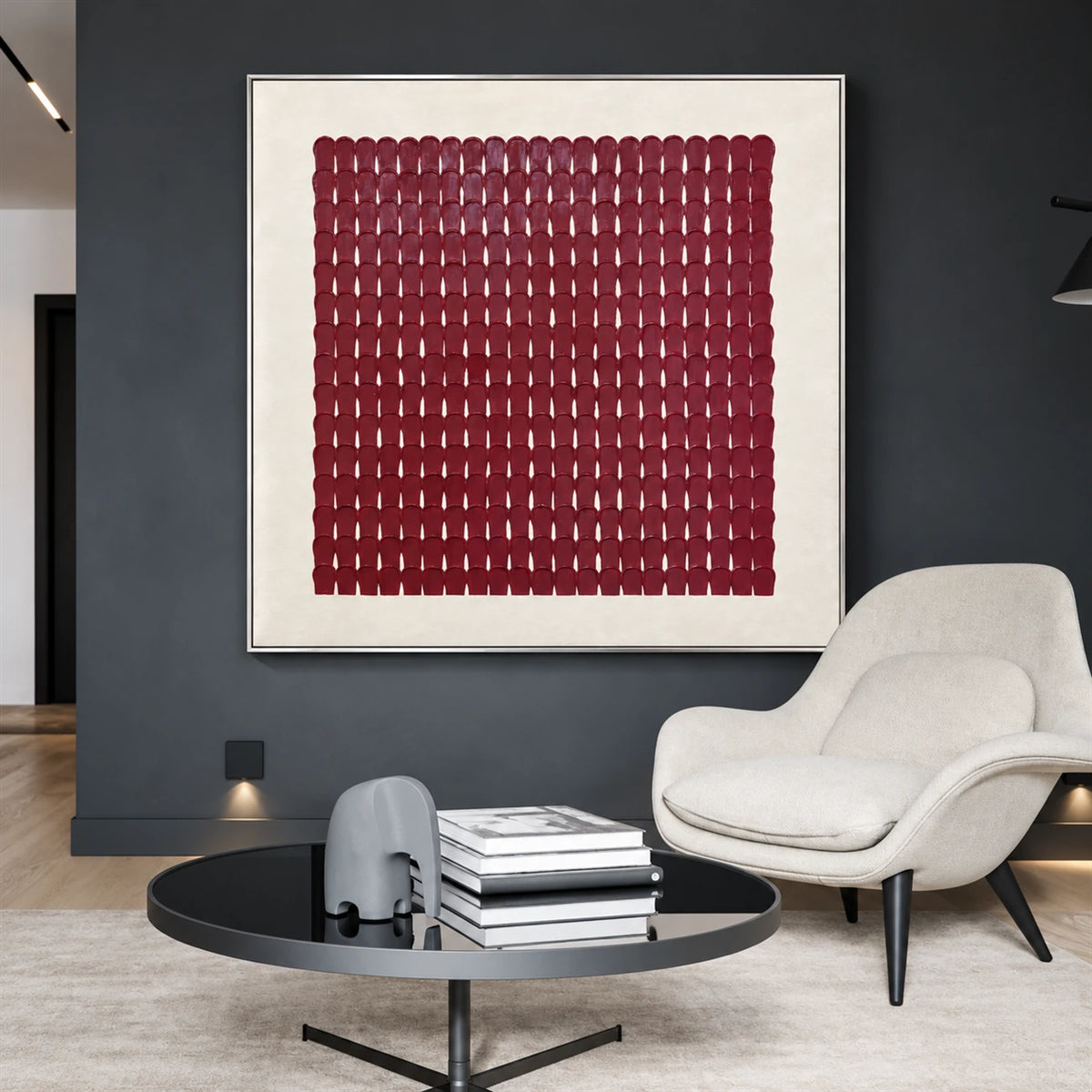 Burgundy Rhythm artwork displayed above a white lounge chair against a charcoal wall.