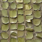 Olive Tessera full artwork. Rounded olive tiles form an irregular patchwork across a dark, textured ground.