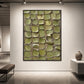 Olive Tessera artwork displayed above a low console on a softly lit wall.