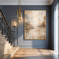 Gilded Haze artwork displayed beside a staircase against a blue-gray wall.