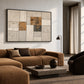 Ochre Masonry artwork displayed above a curved brown sofa.