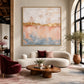 Gilded Blush artwork displayed above a cream sofa and round wooden coffee table.