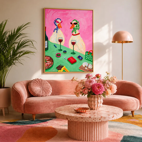 Bistro Ducks artwork displayed above a curved pink sofa with a round coffee table.