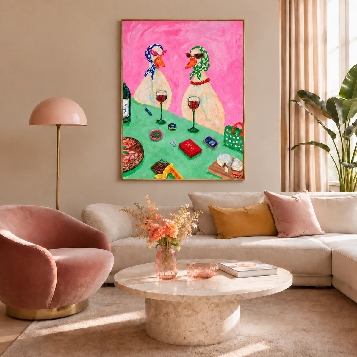 Bistro Ducks artwork displayed above a cream sofa beside a pink lounge chair.
