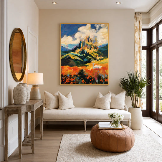 Sunlit Citadel artwork displayed above a cream sofa beside a round ottoman.