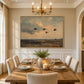 Duskbound Flight artwork displayed above a dining table beneath a chandelier.