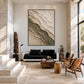 Quiet Strata artwork displayed above a black sofa beside wooden chairs.