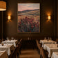 Heather Vale artwork displayed above dining tables in a softly lit restaurant.