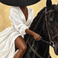 Gilded Equestrian full artwork. A wide black hat conceals the face of a rider dressed in flowing white, seated on a dark horse.