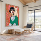 Feline Muse artwork displayed beside a wicker chair beneath exposed beams.