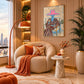 Rosy Brim artwork displayed beside a rounded cream armchair and orange lamp.