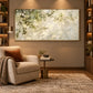 Dappled Branches artwork displayed above a pale armchair beside shelves.