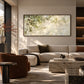Dappled Branches artwork displayed above a light sofa behind a stone table.
