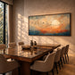 Amber Migration artwork displayed above a dining table with pale chairs.