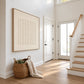 Quiet Fluting artwork displayed beside a staircase in a bright entryway.