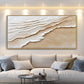 Sandy Tides artwork displayed above a pale sofa beneath spotlights.