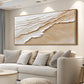 Sandy Tides artwork displayed above a curved cream sectional.
