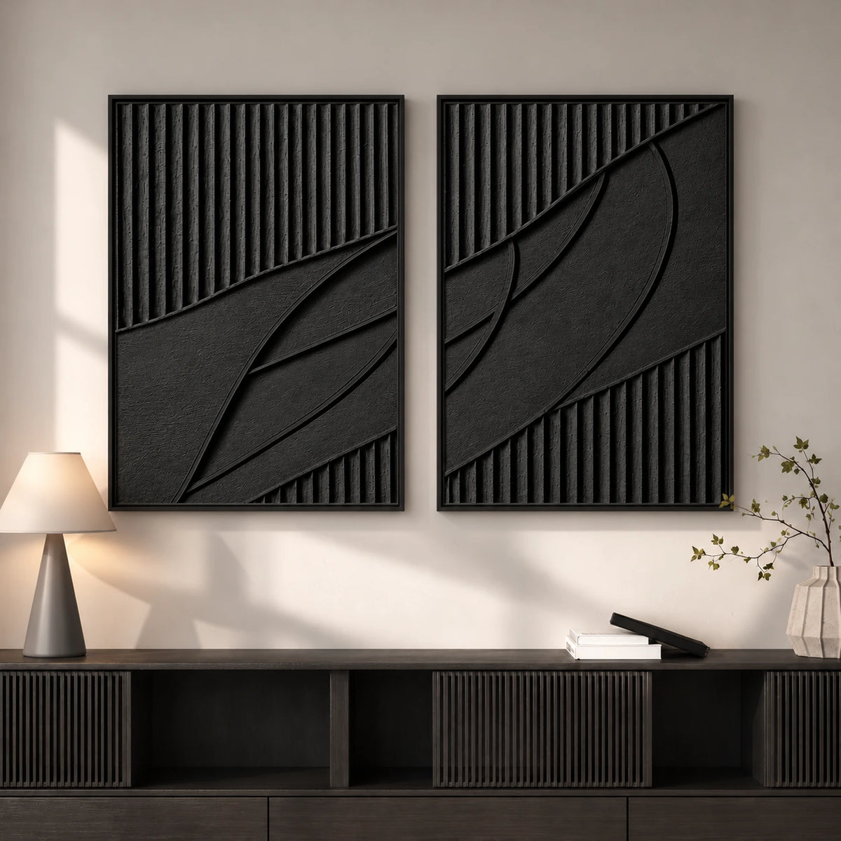 Noir Continuum two-panel artwork set displayed above a dark ribbed cabinet beside a lamp.