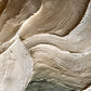 Stonefold Currents full artwork. Broad sculpted folds curve through stone-gray and ivory tones, creating a flowing relief across the composition.