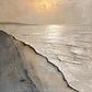 Pale Surf full artwork. A pale sun lights a quiet shoreline where raised ivory waves meet sand and muted blue-gray water.