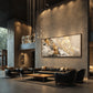 Gilded Confluence artwork displayed above black leather seating in a dark interior.